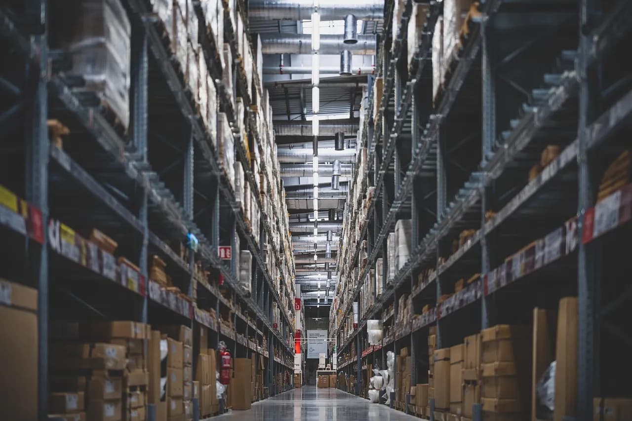 Long warehouse aisle between tall racks stacked with boxes